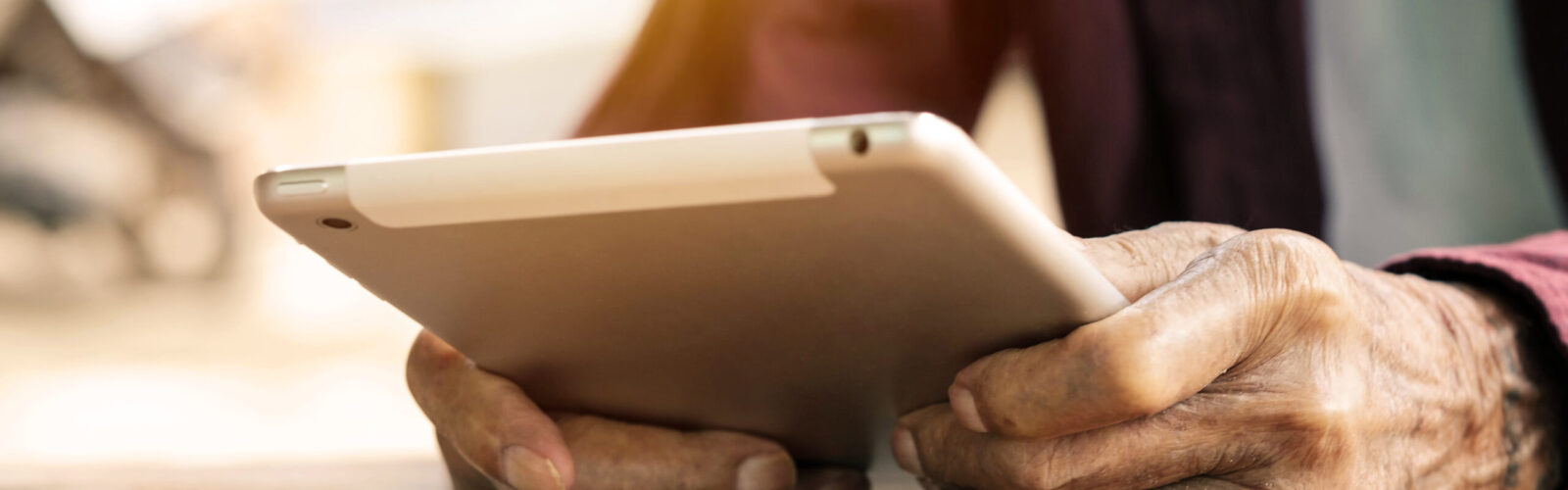 older adult holding a digital tablet