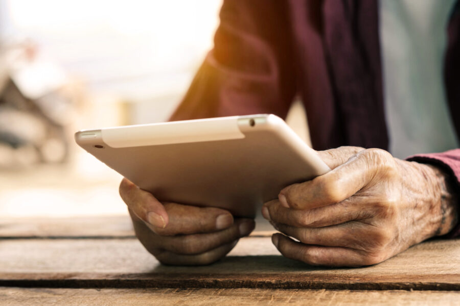older adult holding a digital tablet