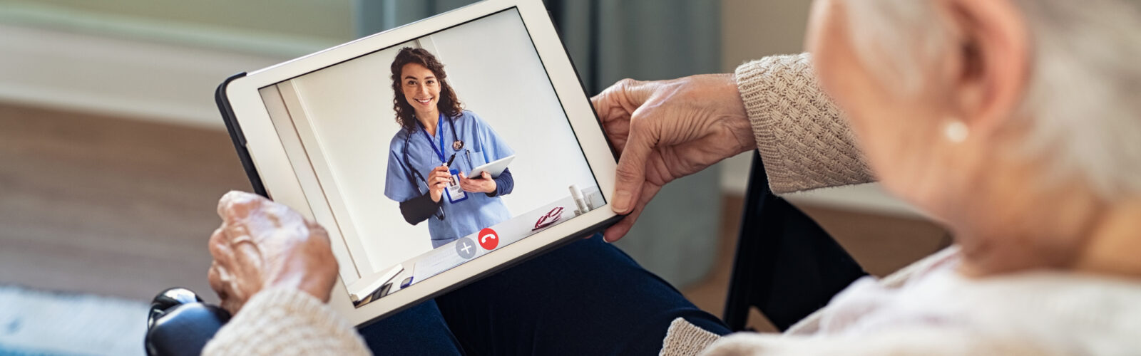 elderly woman working with doctor via iPad