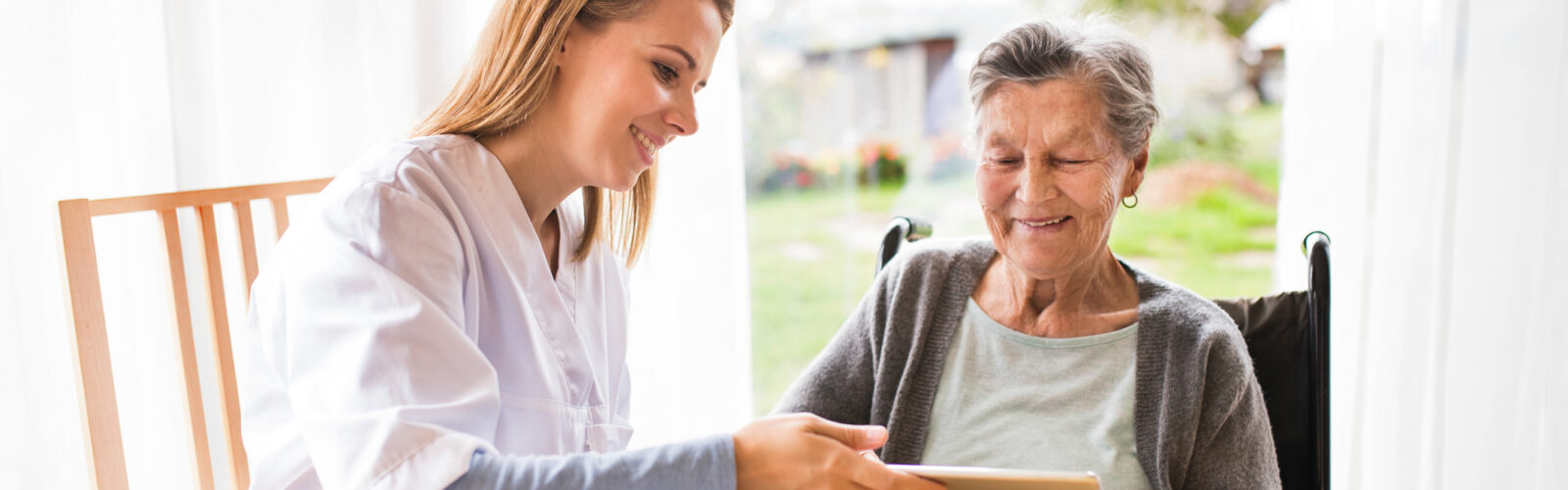 elderly lady at table with young healthcare provider