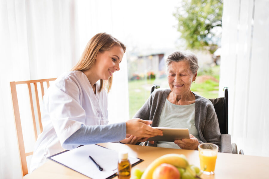 elderly lady at table with young healthcare provider