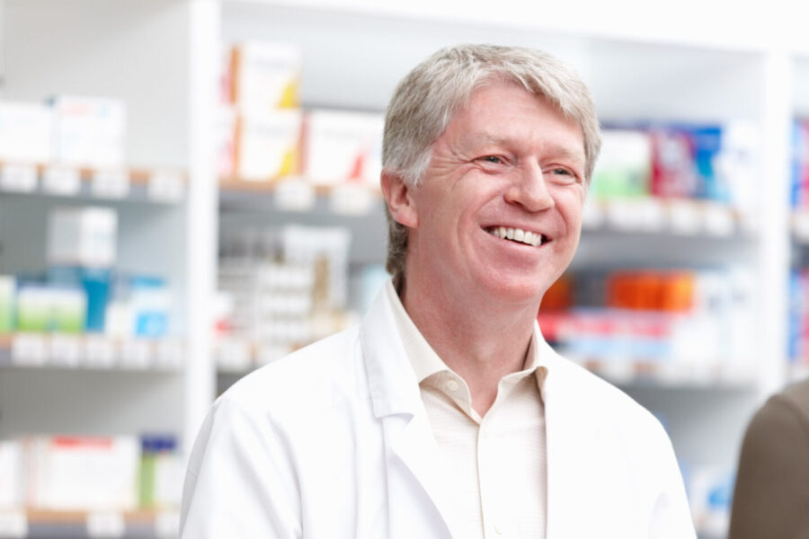 pharmacist behind counter smiling at patient