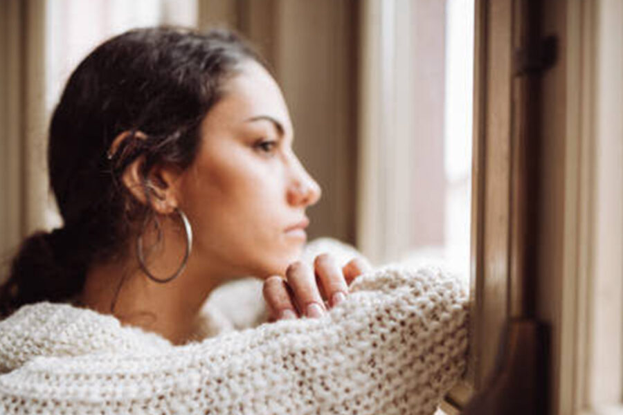 young woman peering out a window