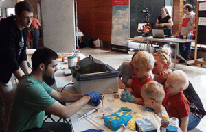 College student doing a chemistry demonstration for little kids