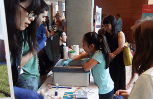 College student doing a chemistry demonstration for little kids