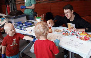 College student doing a chemistry demonstration for little kids