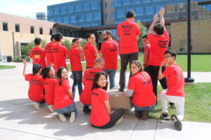 2018 Tang research group in red t-shirts showing back side of shirts