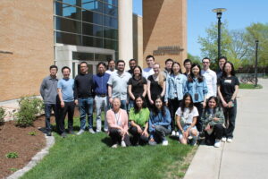 May 2023 Tang Research group photo in front of school of Pharmacy building