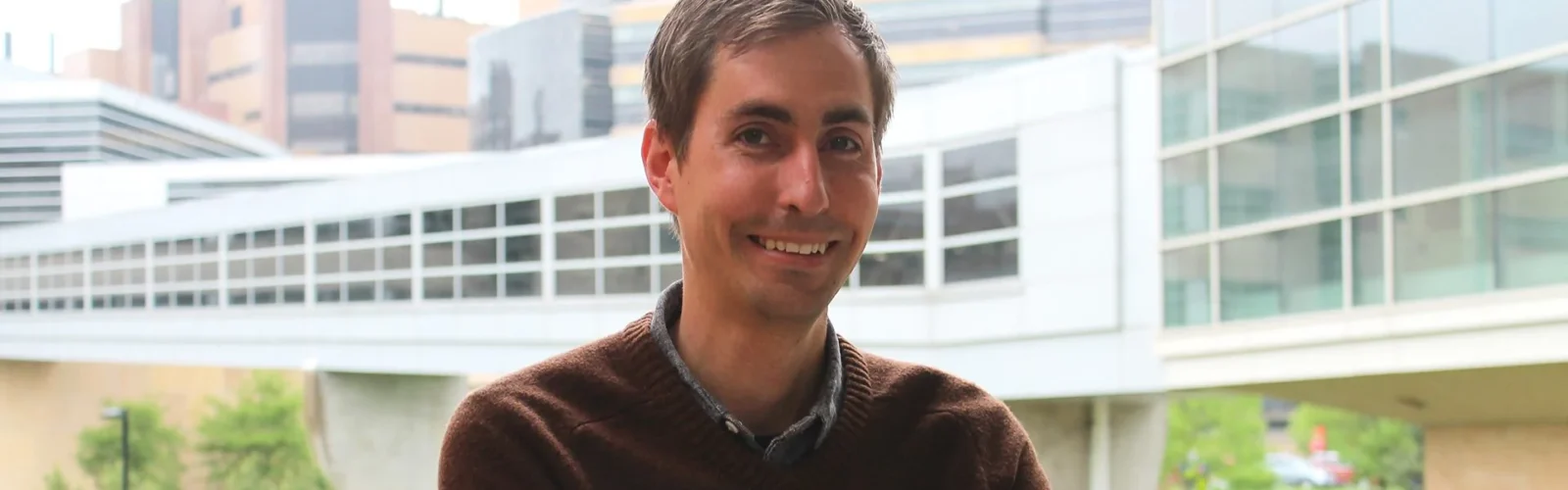 headshot of Cody Wenthuur with HSLC buildings behind