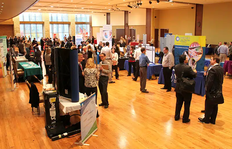 A large crowd of students visits booths at the career fair
