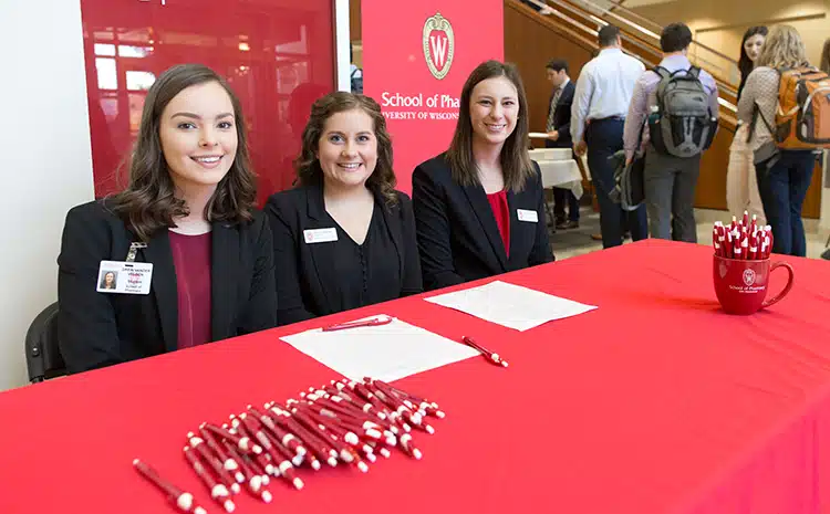 Pharmacy students manning the check-in table await attendees