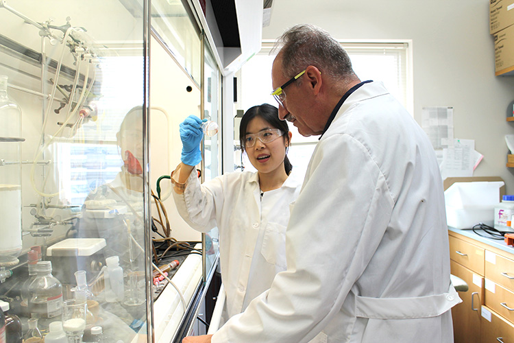 A Pharmsci grad student and her professor discuss a sample from an experiment