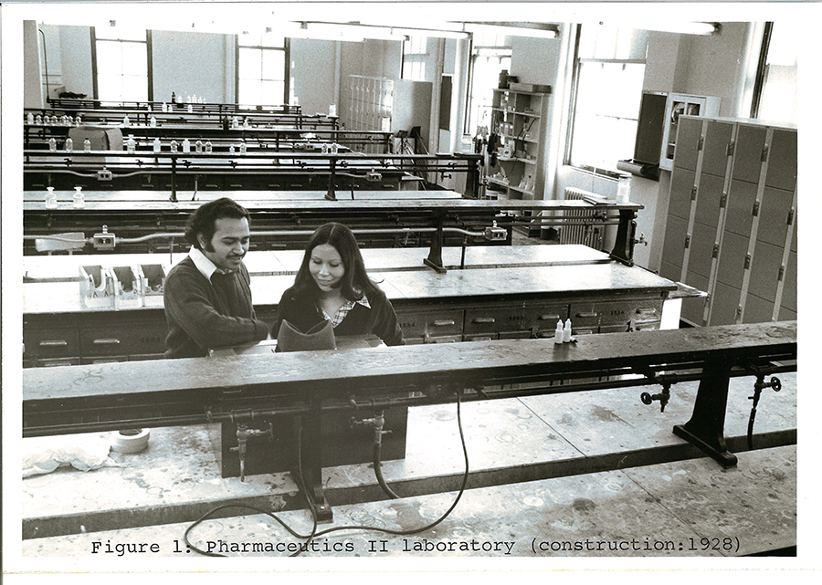 A black-and-white photo of two people in a 1920s lab.