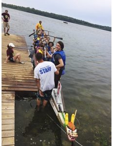 Students in dragon boatMarklie Munroe, team captain and drummer, looks over her shoulder as Paddle PRN returns to the dock after an amazing race at the Capital Lakes DragonFest.