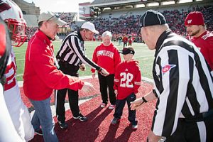 Dean Jeanette Roberts assists with the the coin toss prior to kick-off.