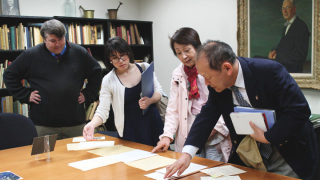 Left-right: Greg Bond, Assistant Director, American Institute of the History of Pharmacy, looks on as Kenia Elena Avendano-Garro, UW-Madison graduate student and translator, Mrs. Inoue, and Mr. Sartoru Inoue (far right), review historical documents.