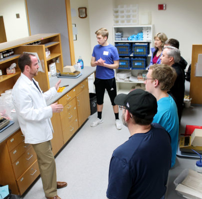 A third-year pharmacy student demonstrates the creation of gummy medications to prospective students at an open house