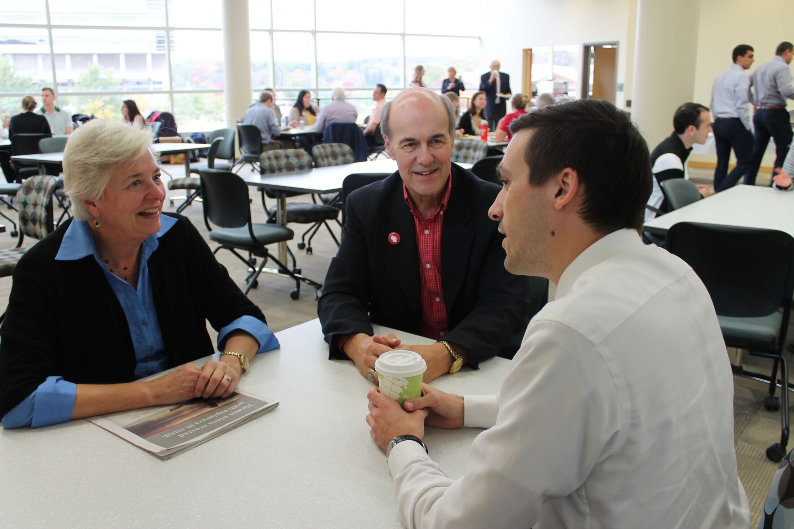 Duane Kirking and his wife sitting at a table with Eric Friestrom