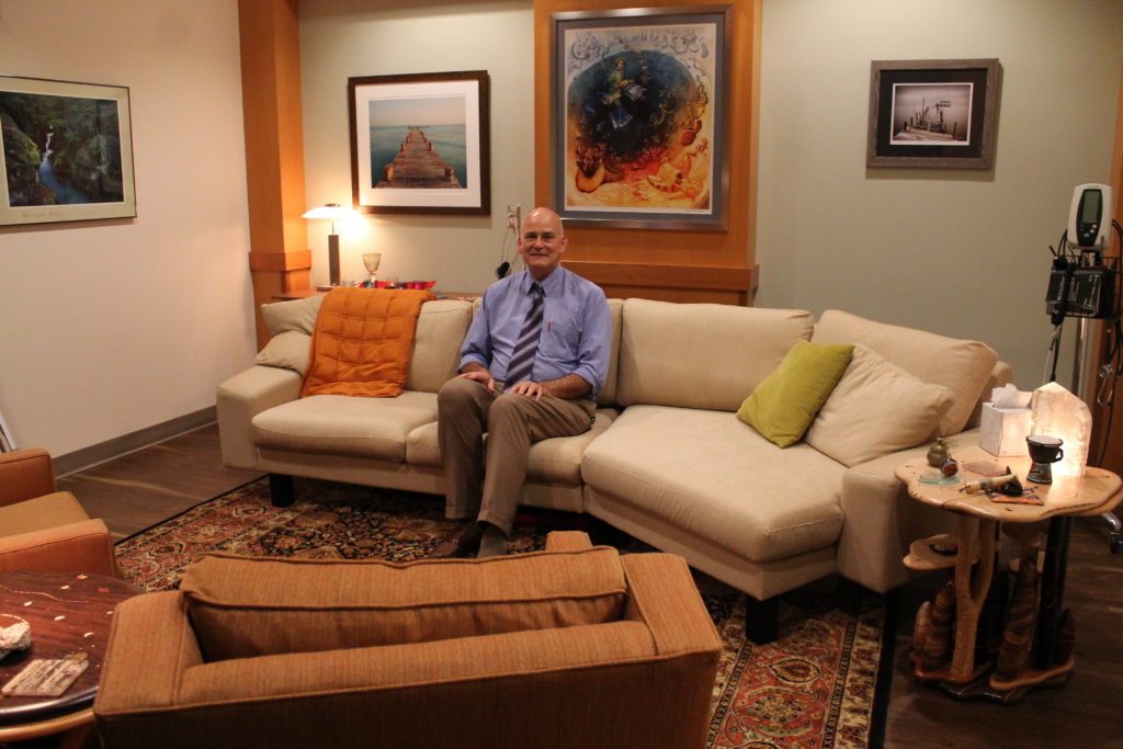 Paul Hutson sitting in the clinical therapy room, which is furnished like a living room.