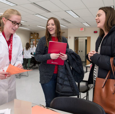 Prospective students ask a third year pharmacy students about pharmacotherapy lab class