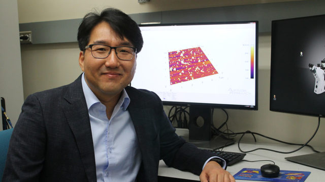 Seungpyo Hong at his desk with a 3D rendered image on his computer