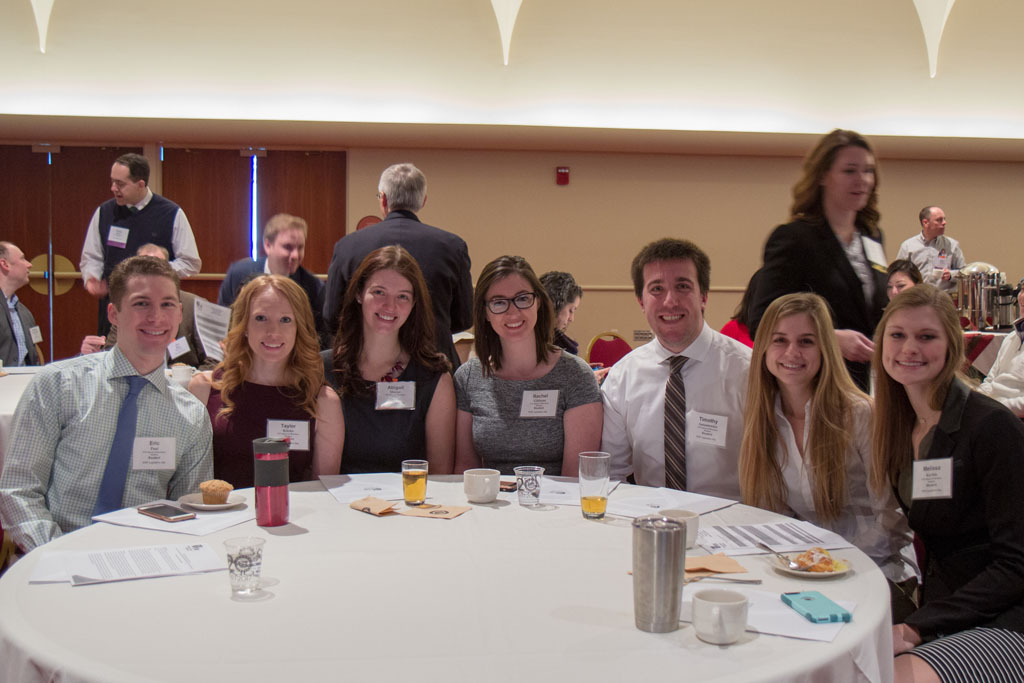 Small group of students gathered around table at an event