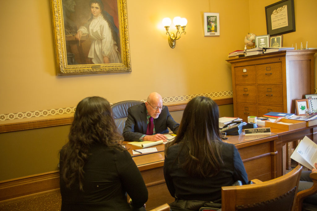 Pharmacy students listening to a legislator at his desk