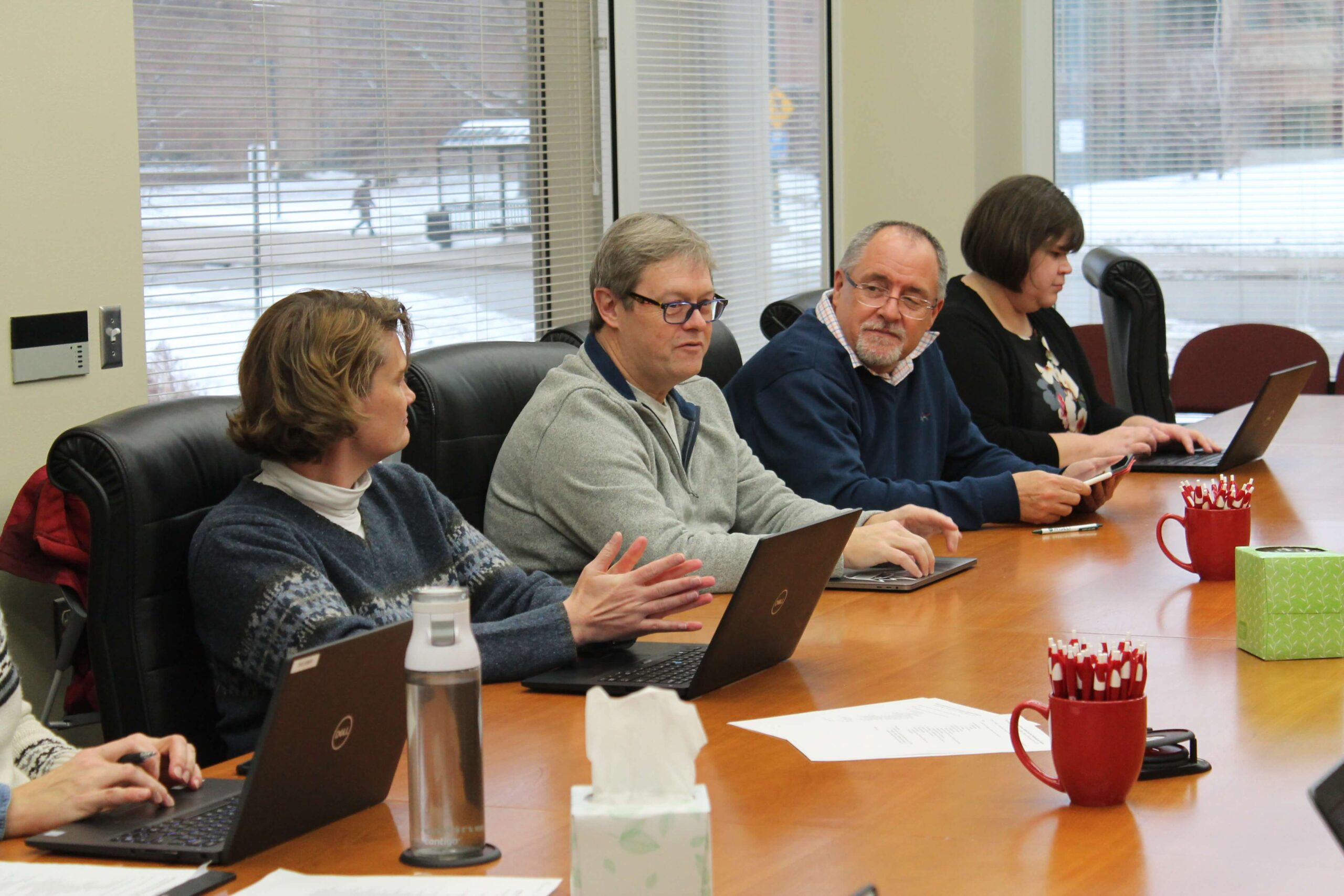 Chuck Lauhon and Mel de Villiers speaking in a meeting with campus partners