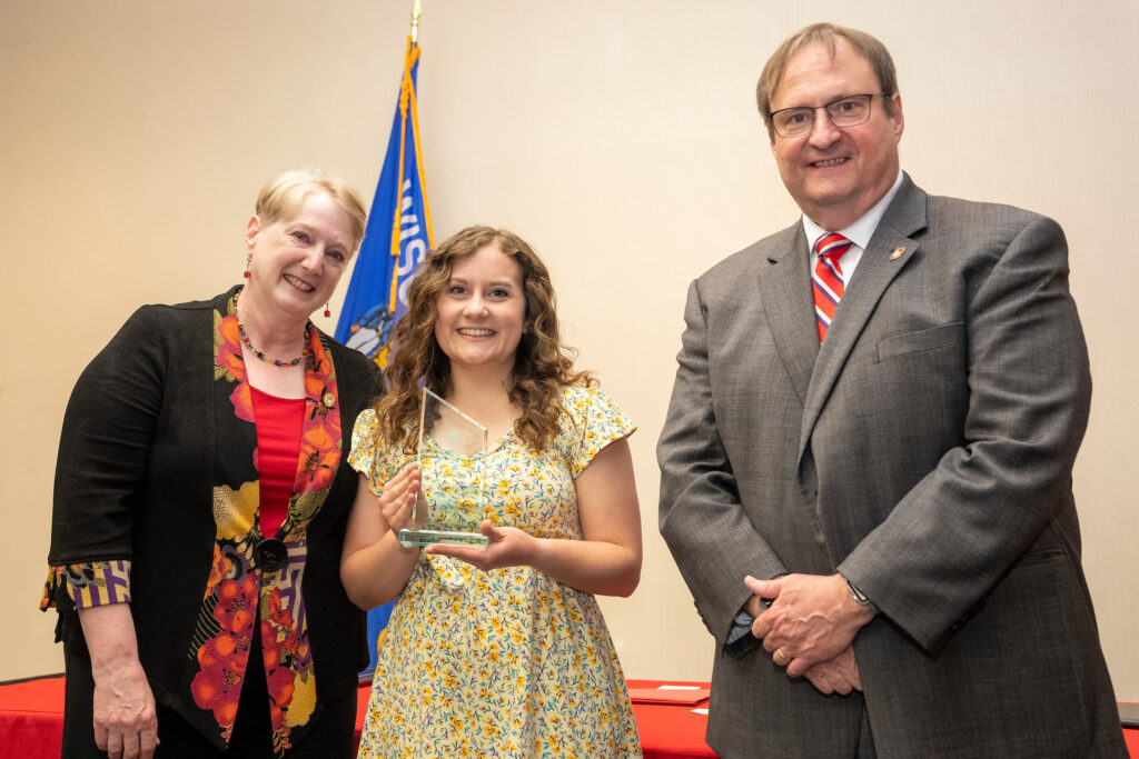 An award-winner poses with Karen Kopacek and Dean Steve Swanson.