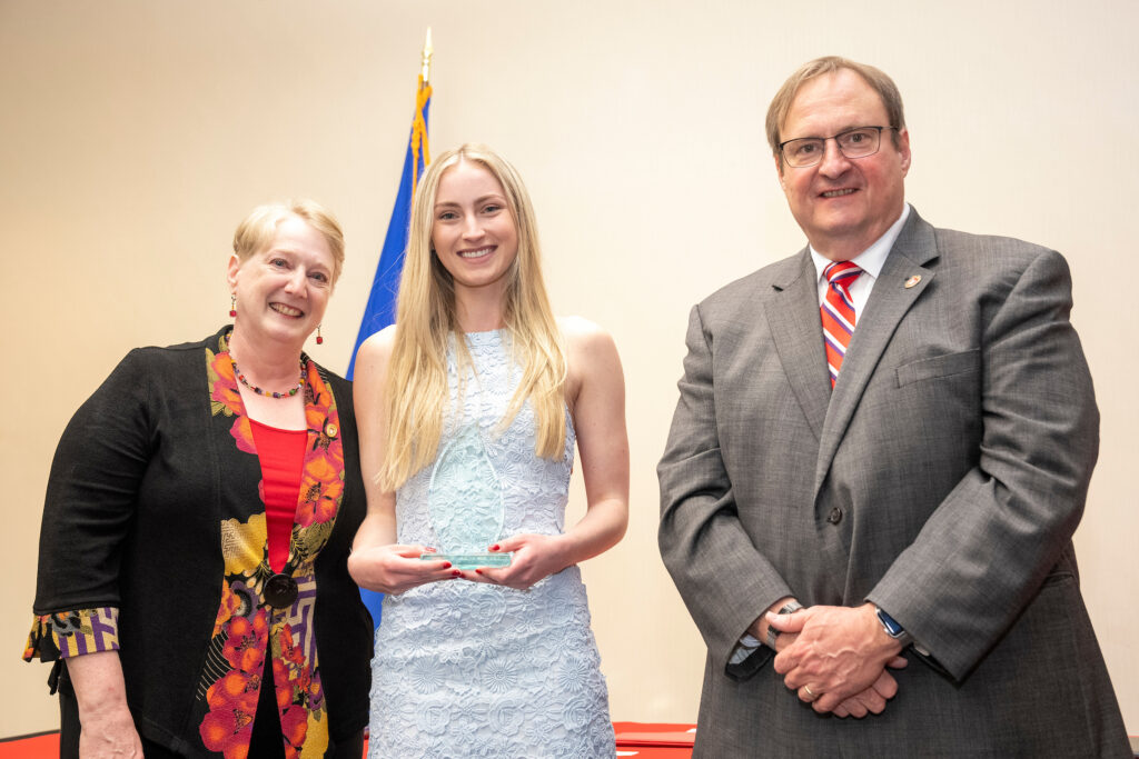 An award-winner poses with Karen Kopacek and Dean Steve Swanson.