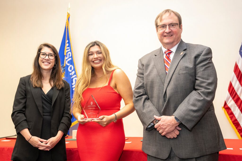 Salma Abdelwahab poses with an award, Dean Steve Swanson, and Lisa Imhoff.