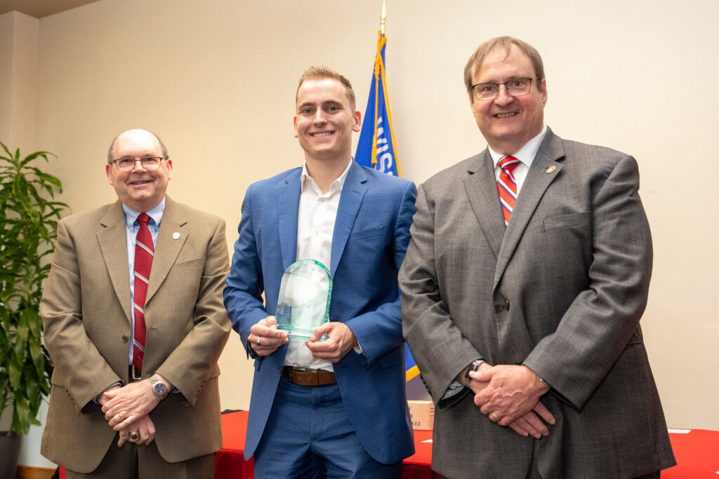 An award-winner poses with Dean Steve Swanson and Ed Elder.