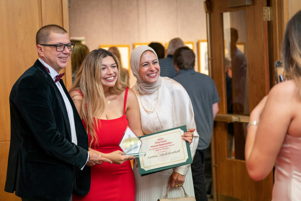 A PharmD award winner poses with her family and awards.