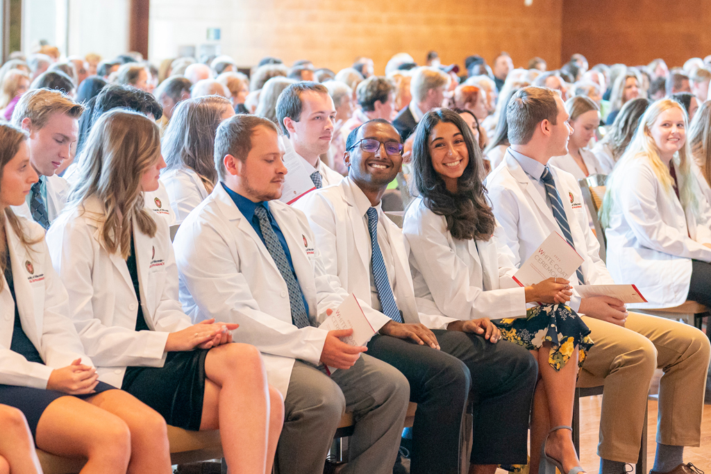 Students sitting with their white coats on