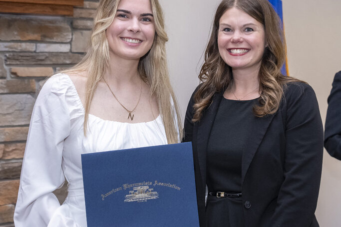 A graduate receives an award from Andrea Porter