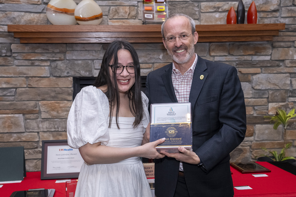 A graduate receives an award from Dave Mott
