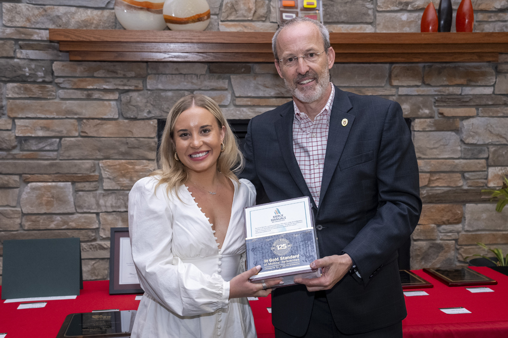 A graduate receives an award from Dave Mott