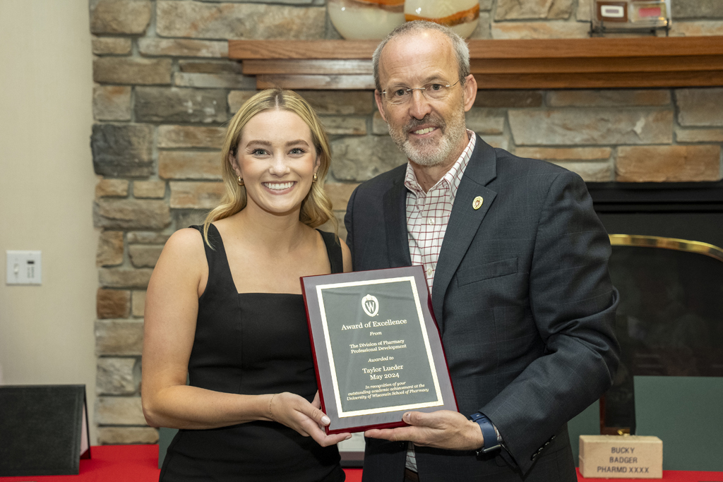 Taylor Lueder receives an award from Dave Mott