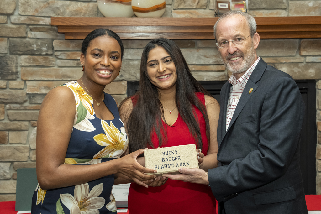 Maria Hill and another graduate receive legacy bricks from Dave Mott