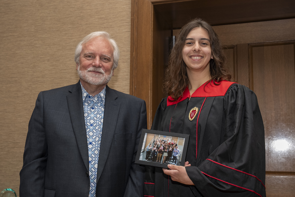 A student accepts a class photo from Jeff Johnson