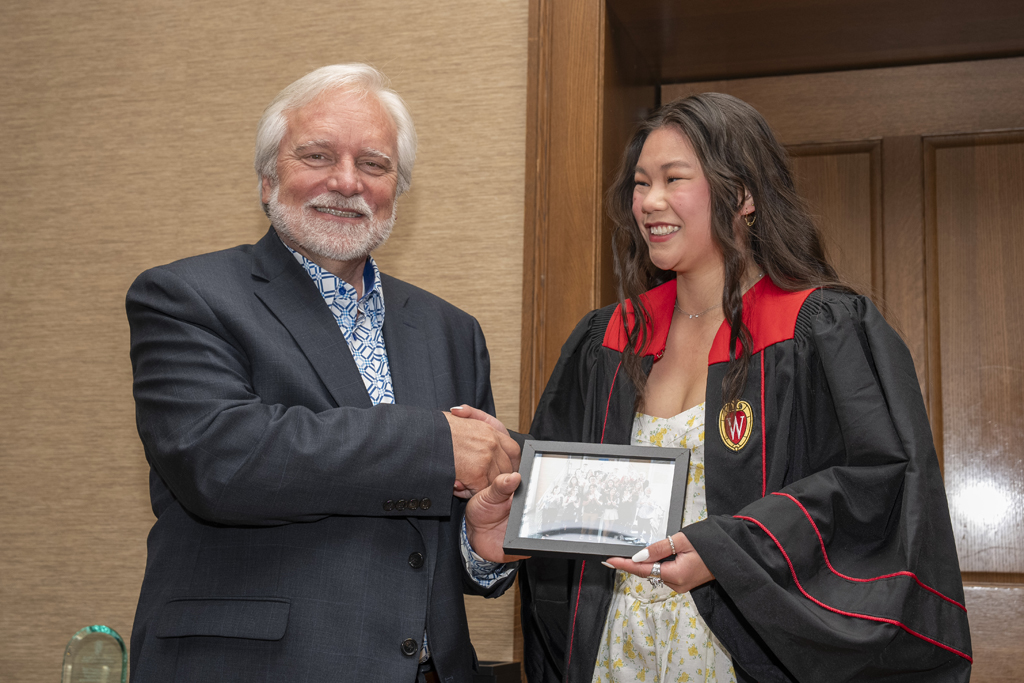 A student accepts a class photo from Jeff Johnson