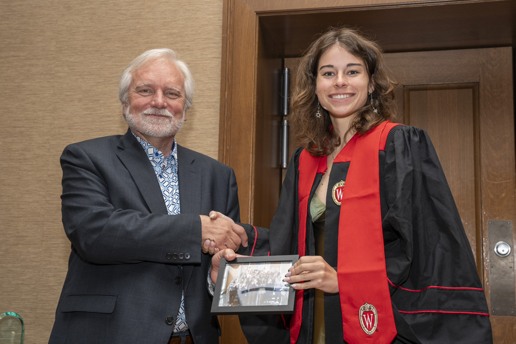 Isabella Jones accepts a class photo from Jeff Johnson