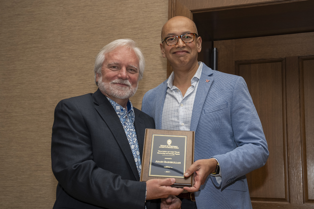 Arash Bashirullah accepts his Teacher of the Year award from Jeff Johnson