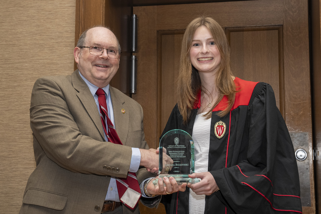 Leyana Budzynski receives an award from Ed Elder