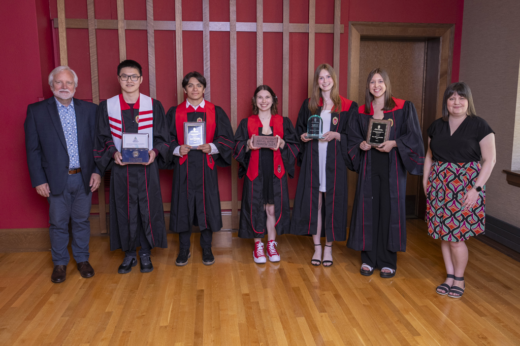 Jeff Johnson and Kendra Gurnee pose with five award-winning graduates