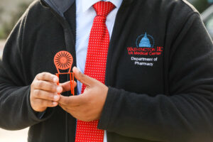 Berook Addisu holding a tiny version of the sunburst chairs from the Memorial Union Terrace