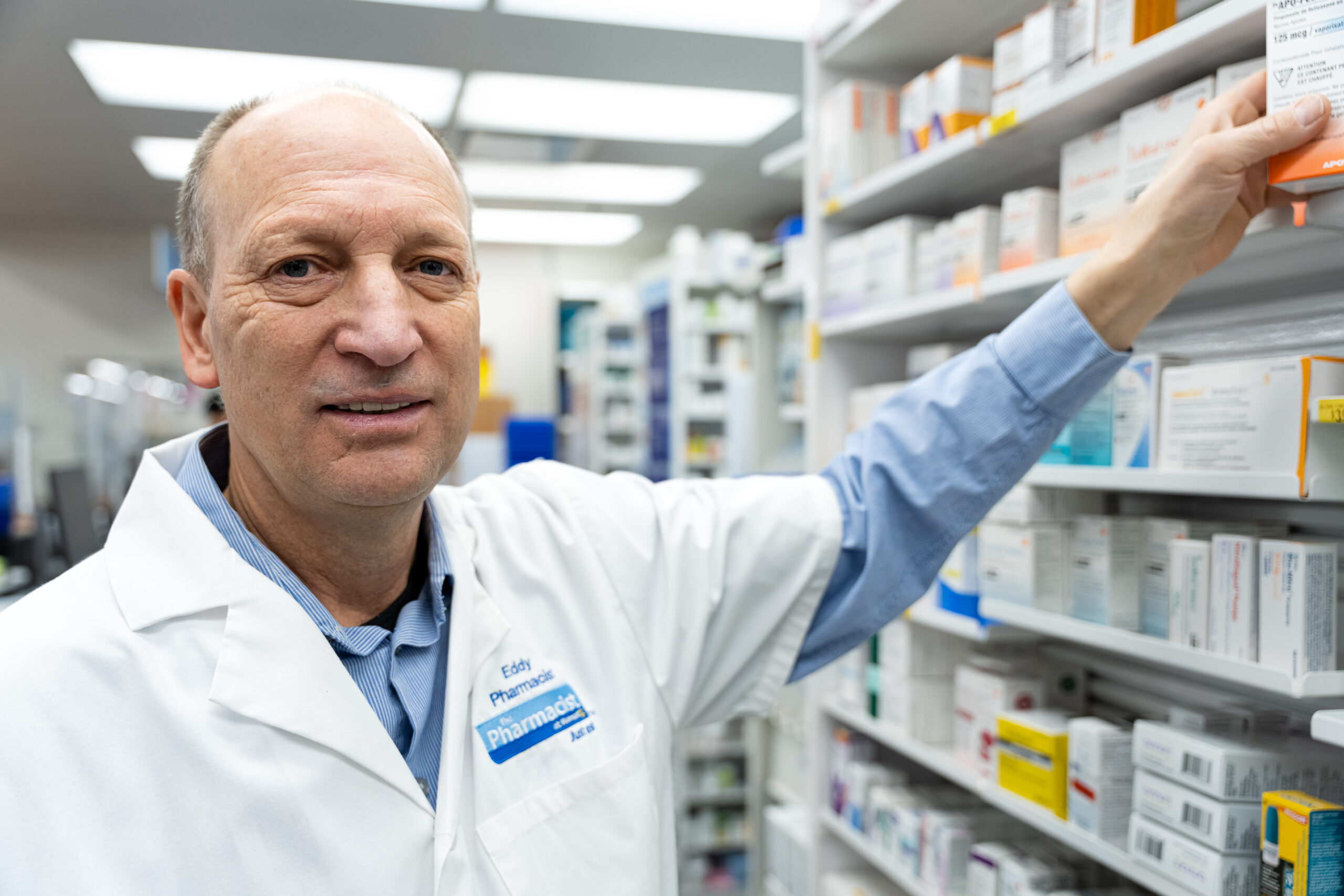 Ed Lebler getting medication from a shelf in the pharmacy.