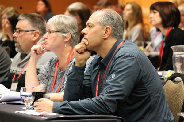 Pharmacy conference attendees listen to a guest speaker presentation