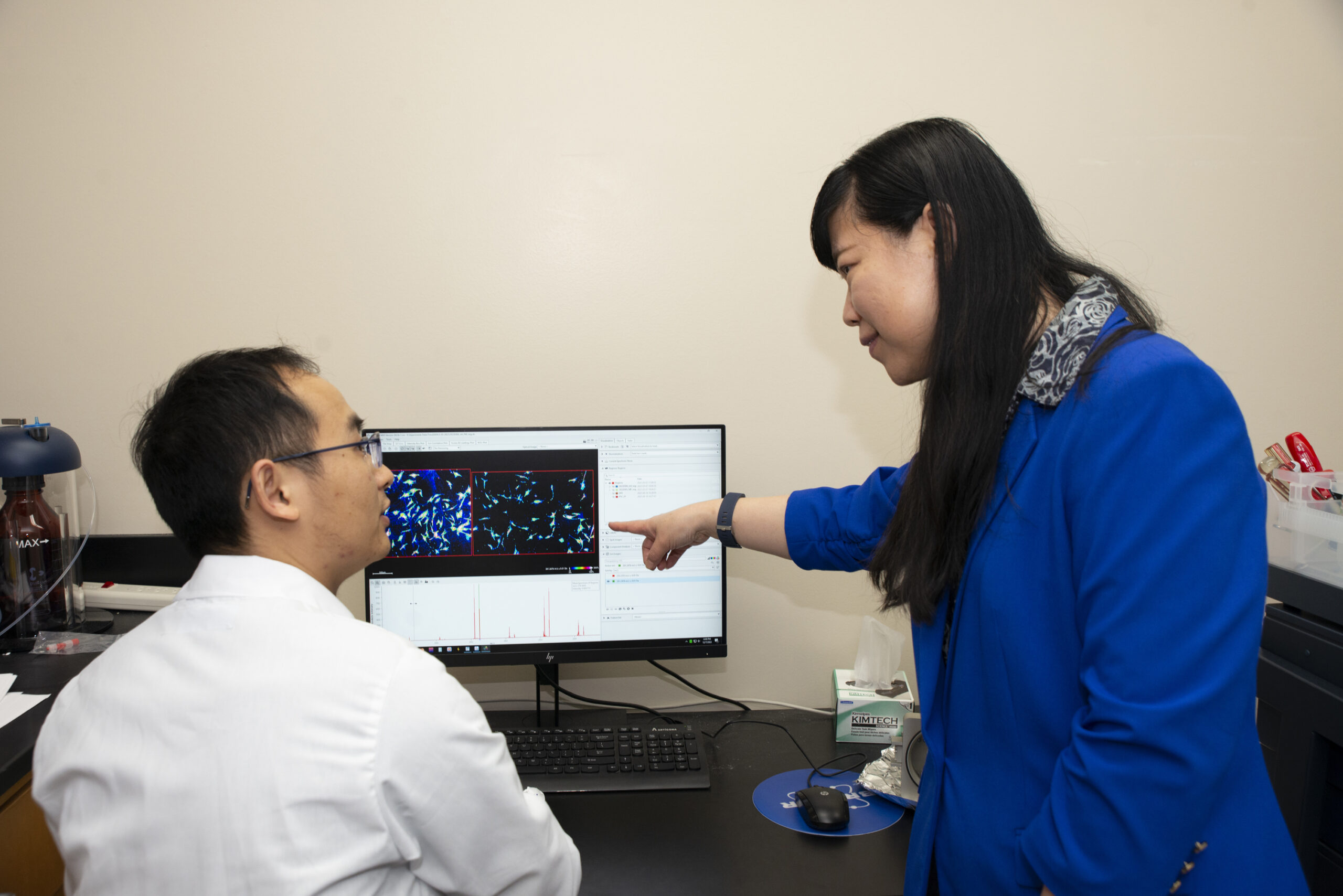 Here, Li (right) talks with Zhang about phospholipids produced in pancreatic stromal cells.