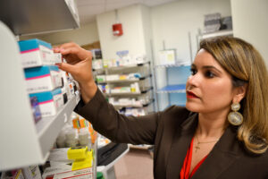 Melissa Ortega taking medication from a shelf